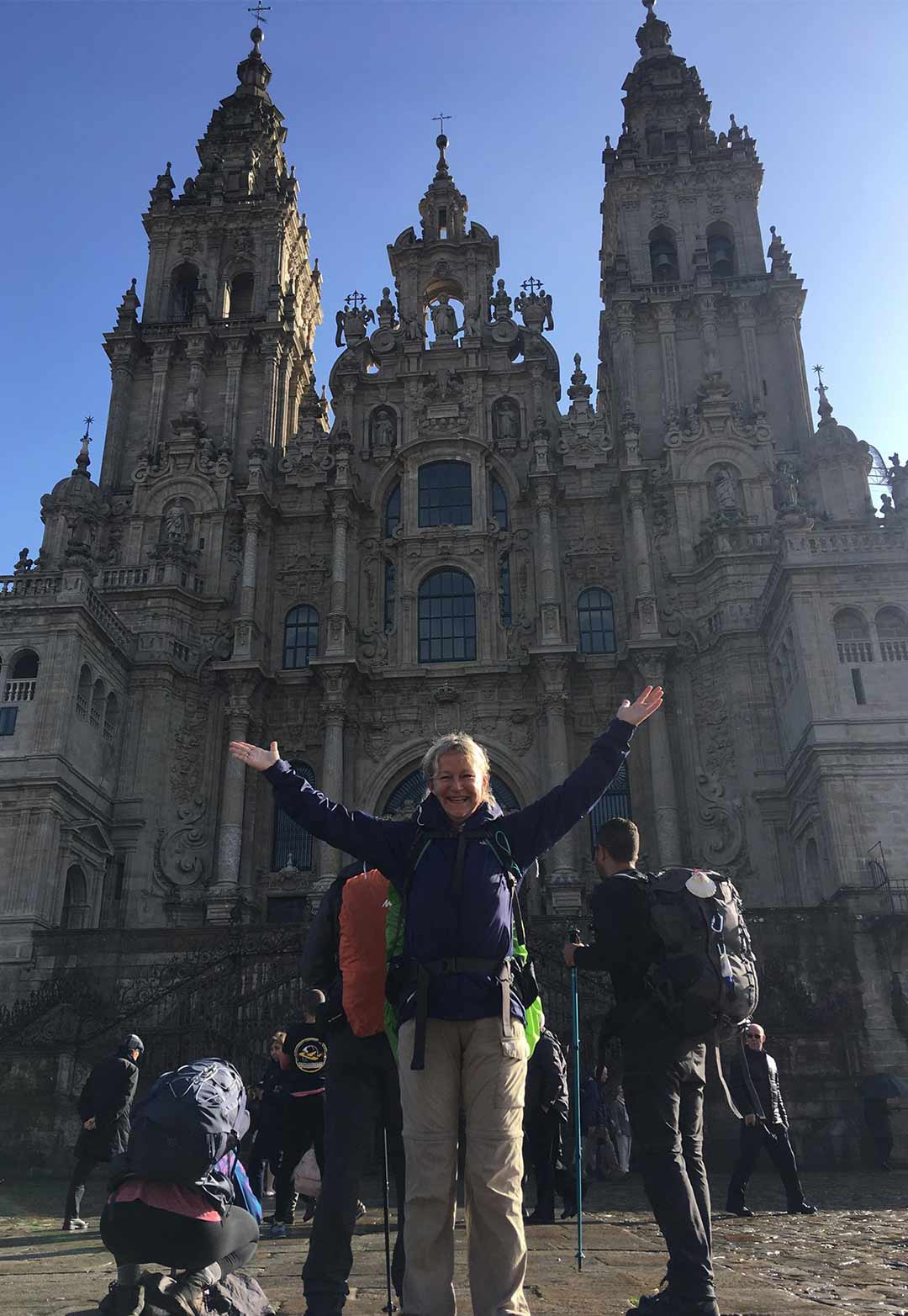 Kristina with arms open wide in front of the cathedral in Santiago de Compostela